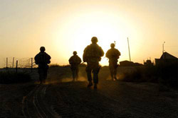 Soldiers walking into a sunset