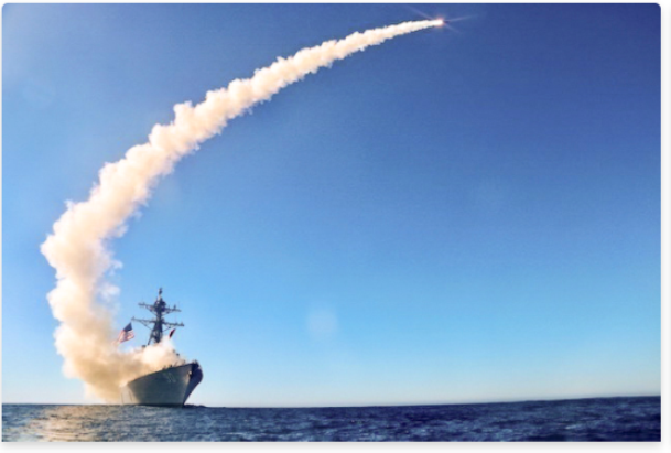 Photo of a navy ship firing a missile 